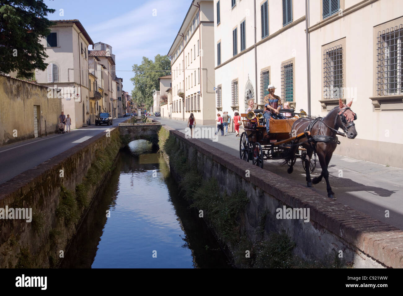 I turisti prendono cavallo e gite in carrozza sulla via del Fosso in Lucca accanto al corso waer. Foto Stock