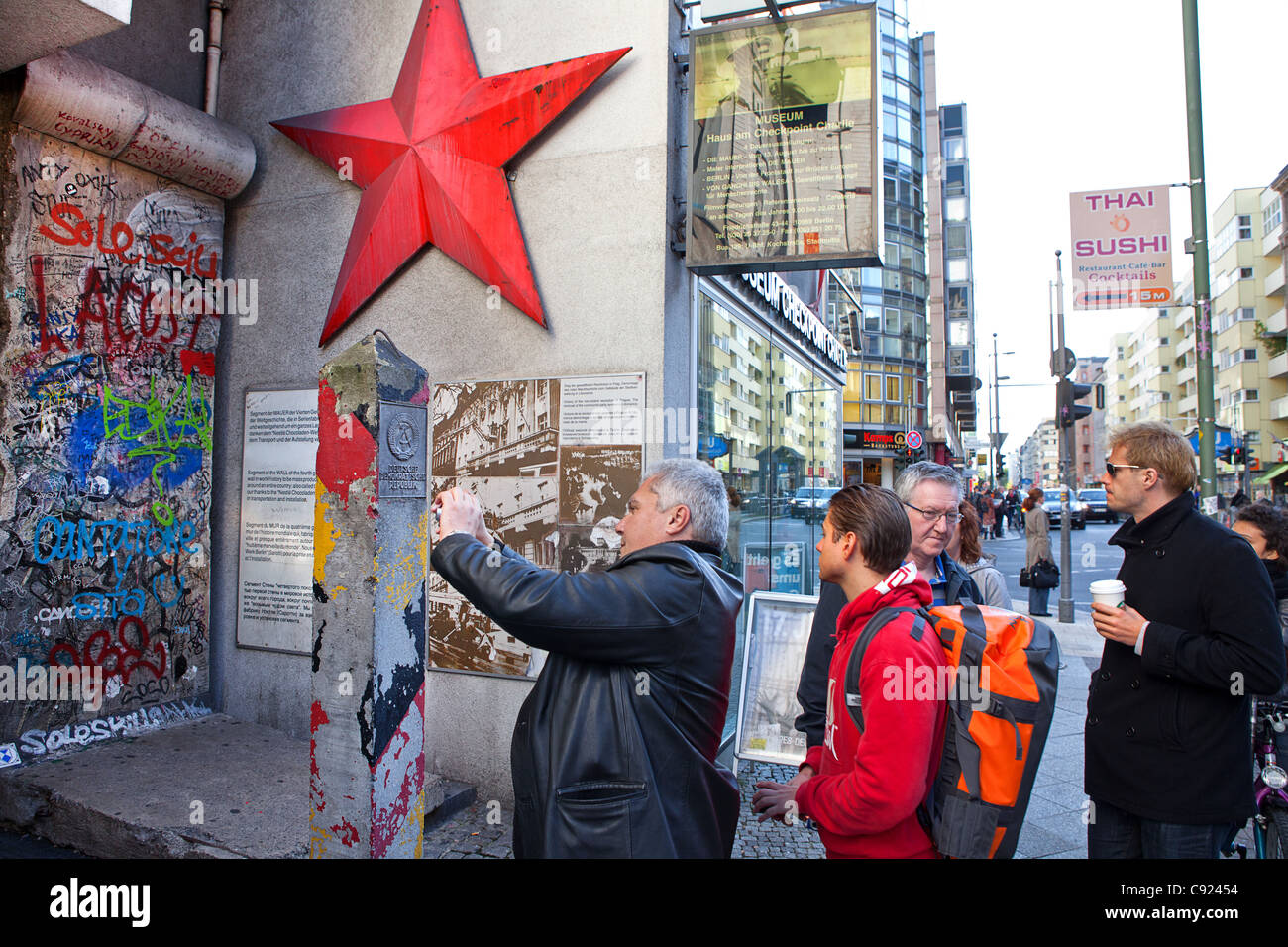 Turista nella ex RDT est-ovest frontiera tedesca a Friedrichstrasse nella parte anteriore del Checkpoint Charlie house, Berlino, Germania Foto Stock