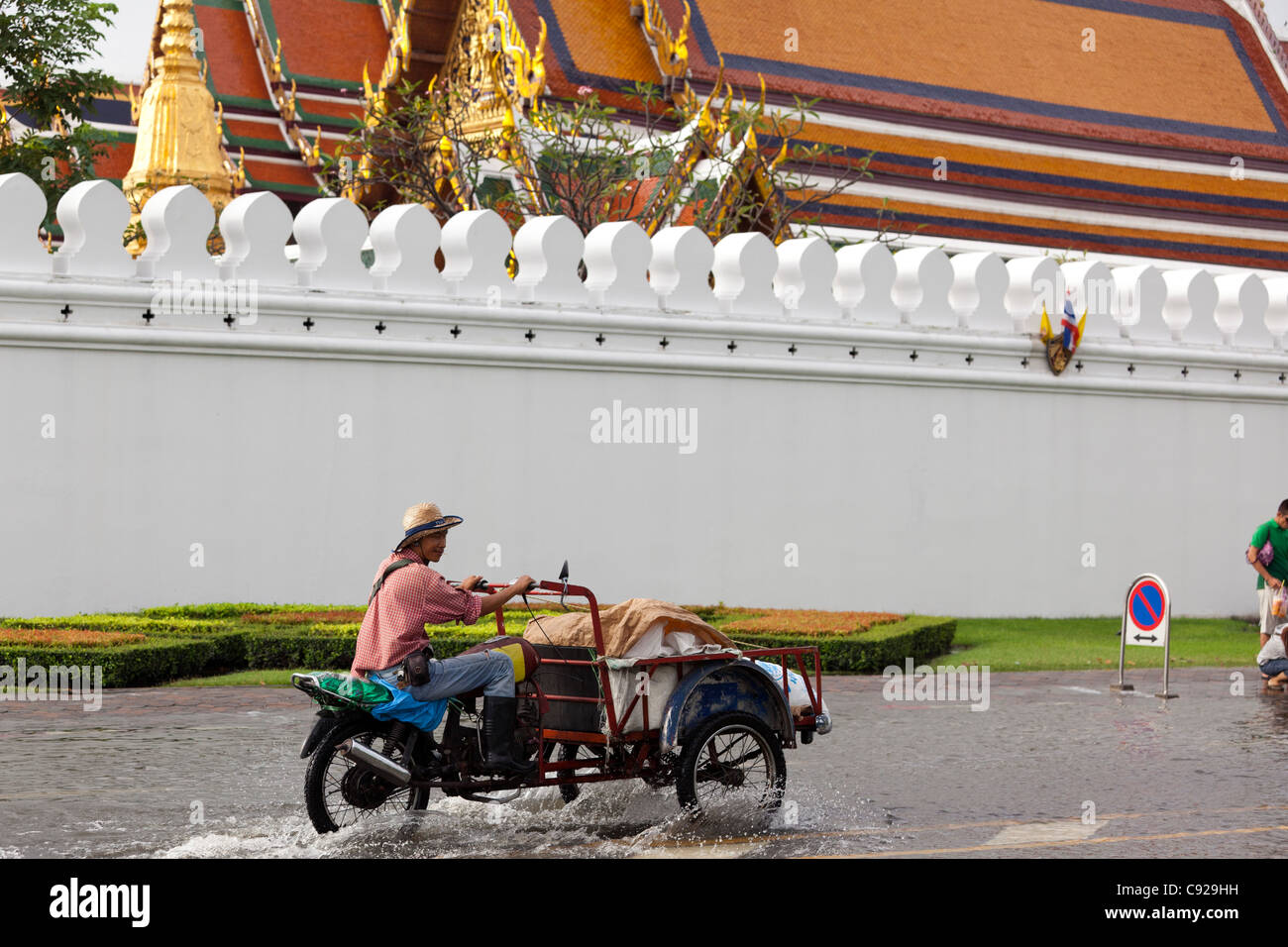 Commerciante di guida attraverso l'acqua di allagamento in Bangkok city centre, Thailandia Foto Stock