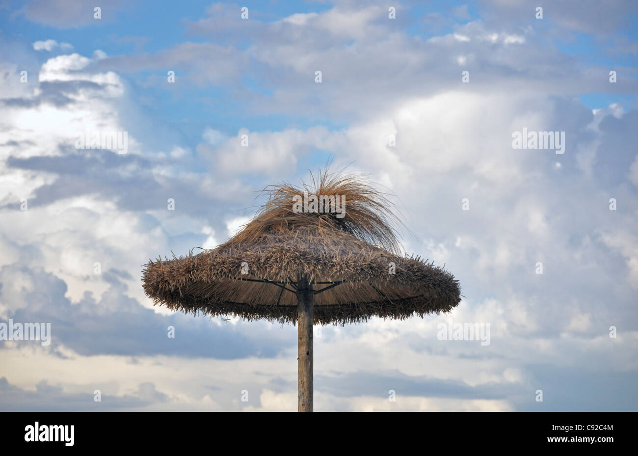 Ombrello di paglia contro il cielo nuvoloso, Mallorca, Spagna, Europa Foto Stock