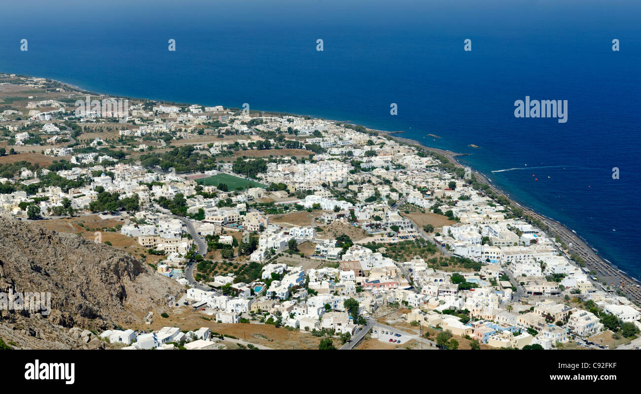 Santorini. Le Cicladi. La Grecia. Vista aerea dalla vetta del monte Profitis Ilias della spiaggia di sabbia nera località di Kamari. Foto Stock