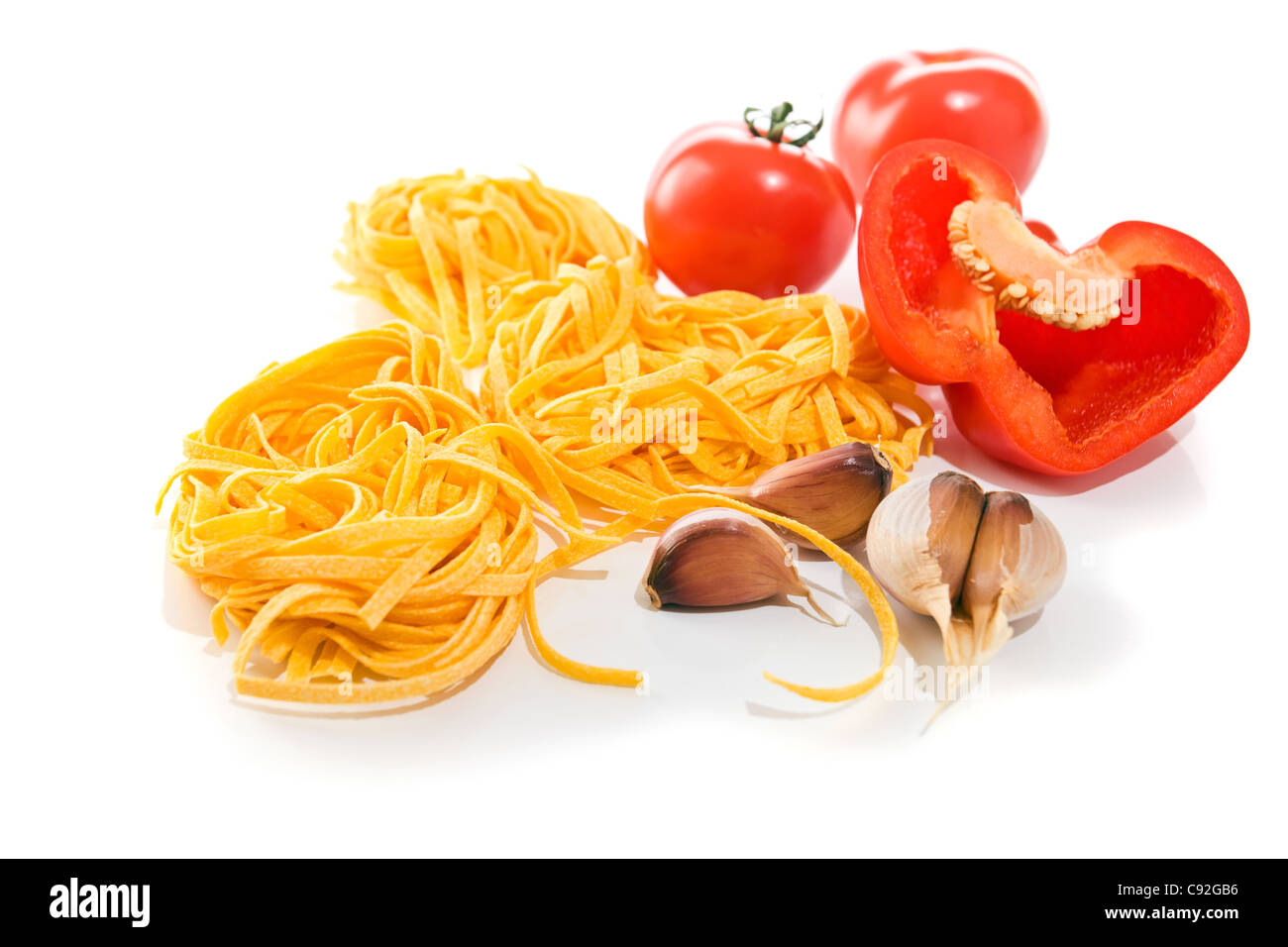 Ingredienti : pasta, pomodoro, aglio e peperoncino su uno sfondo bianco. Foto Stock