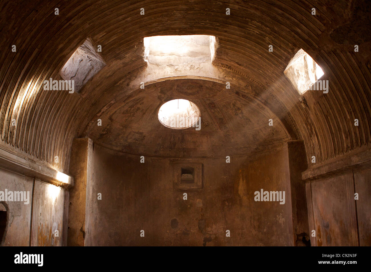 Una camera entro il Forum bagni il Calidarium absidale dei bagni caldi con un albero di luce in entrata attraverso il tetto. Pompei fu Foto Stock