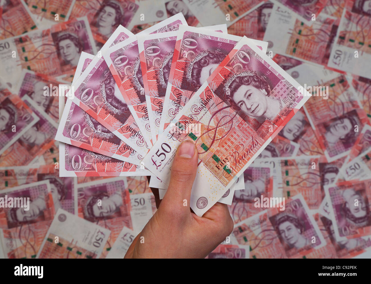 Mano piena di nuovo £50 cinquanta pound note sullo sfondo di 50 banconote ricchi ricchi Foto Stock