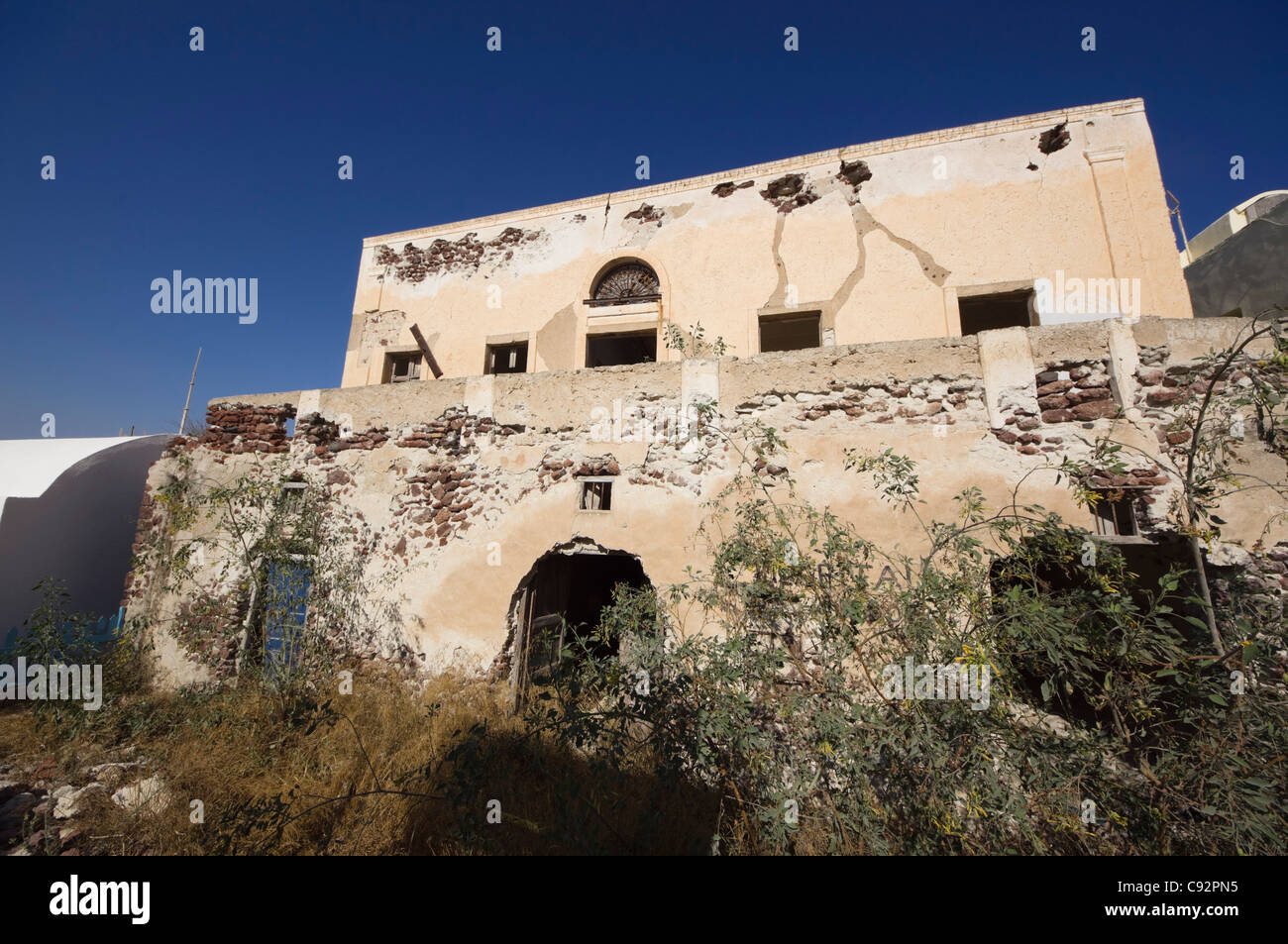 Santorini - villaggio di Oia. Casa sinistra derelitti come terra ha un prezzo così alto è meglio venduti per lo sviluppo. Foto Stock