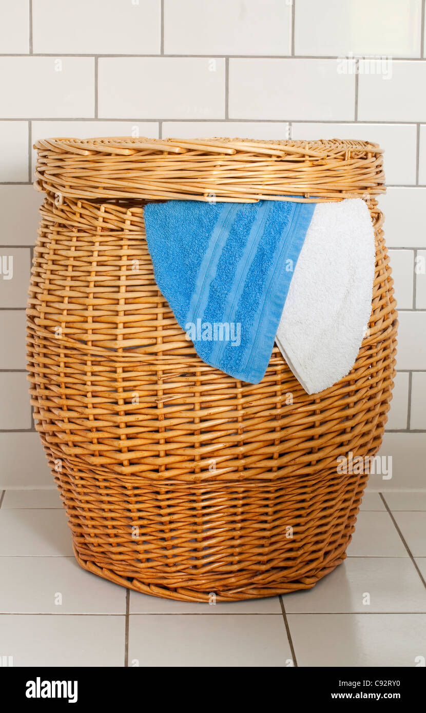 In vimini un cesto per la biancheria in un bagno rivestito di piastrelle  Foto stock - Alamy