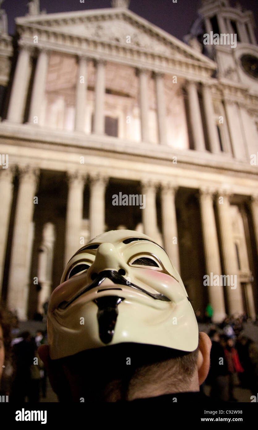 Maschera di Guy Fawkes sul retro del manifestante testa di occupare Londra protesta camp di notte la Cattedrale di St Paul Londra Inghilterra REGNO UNITO Foto Stock