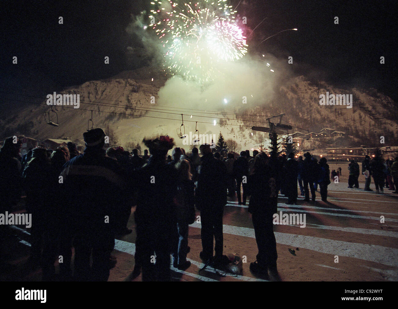 Persone che guardano il nuovo anno fuochi d'artificio del millennio sera sulle piste della Val d'Isere nelle Alpi francesi. Foto Stock