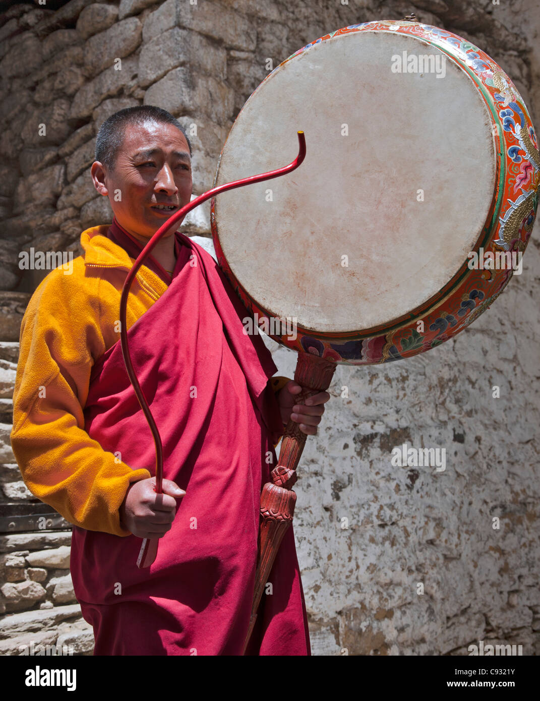 Un monaco buddista a Kurjey Lhakhang tempio con un cerimoniale di nga tamburo chen. Foto Stock