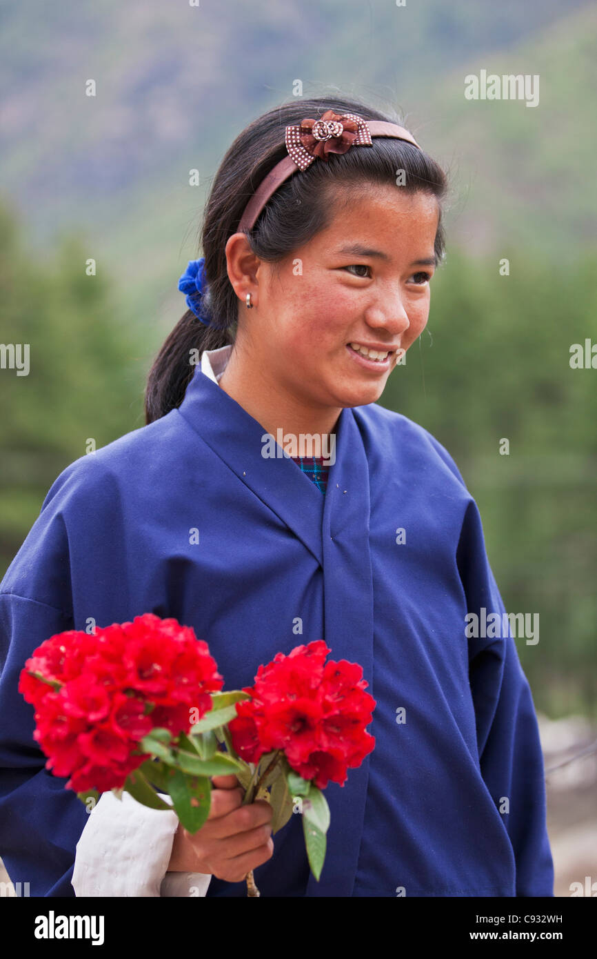 Uno studente con un mazzetto di rossi rododendri, che aveva raccolto nella parte superiore di Paro Valley. Foto Stock