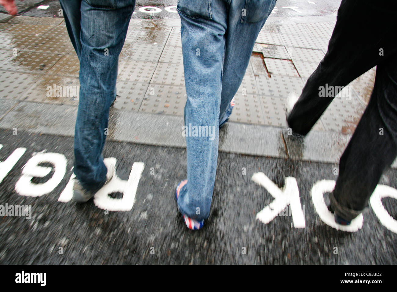 Pedone indossando le infradito con la bandiera inglese. Foto Stock