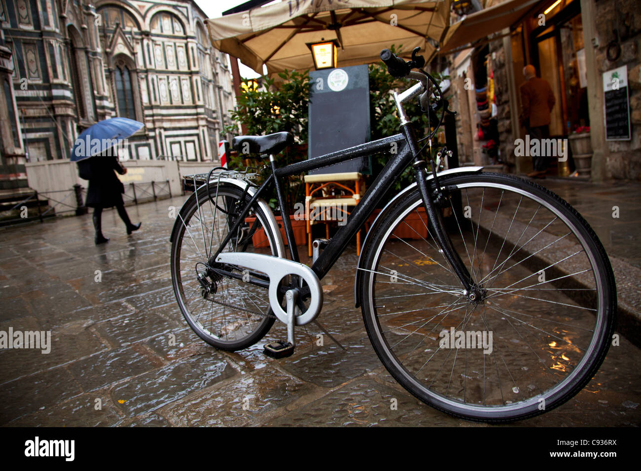 L'Italia, Firenze, Toscana, Europa occidentale; una bicicletta in piedi di fronte ad un ristorante con il duomo sull'altro lato Foto Stock