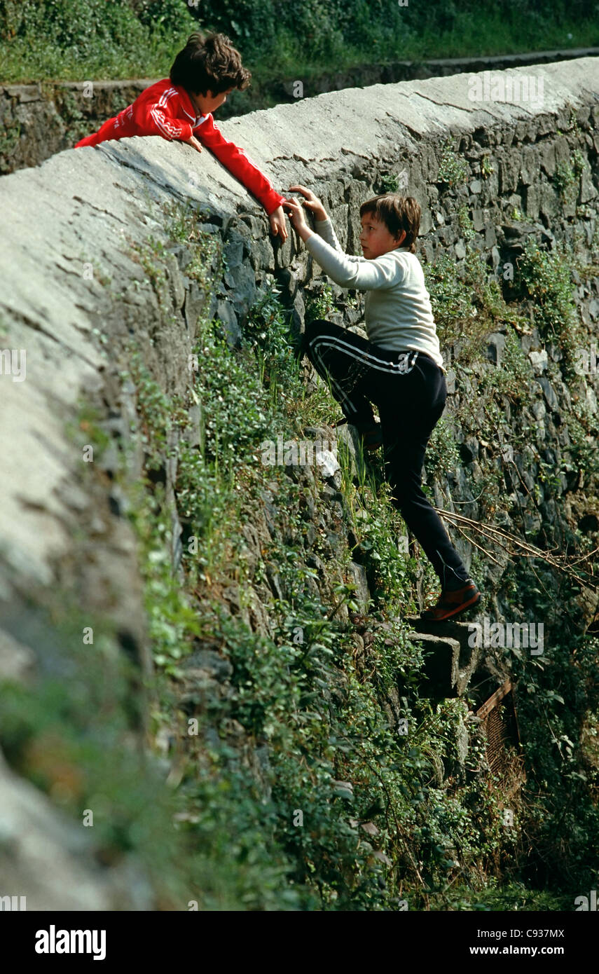 Due ragazzi arrampicata parete di pietra in Francia Foto Stock