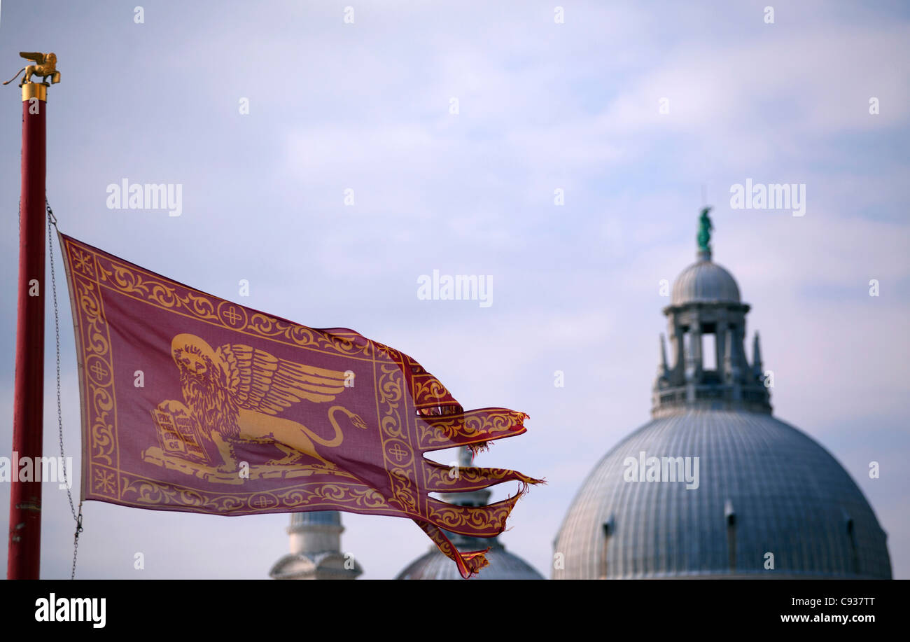 Venezia, Veneto, Italia; la bandiera veneziana con dettaglio di cupole della chiesa di Santa Maria della Salute Foto Stock