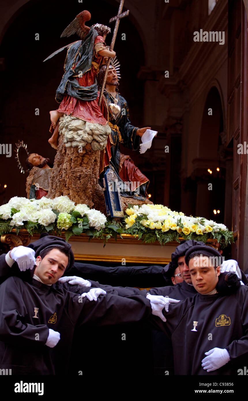 Sicilia, Italia, giovane uomo che porta la statua di Gesù in Trapani Foto Stock