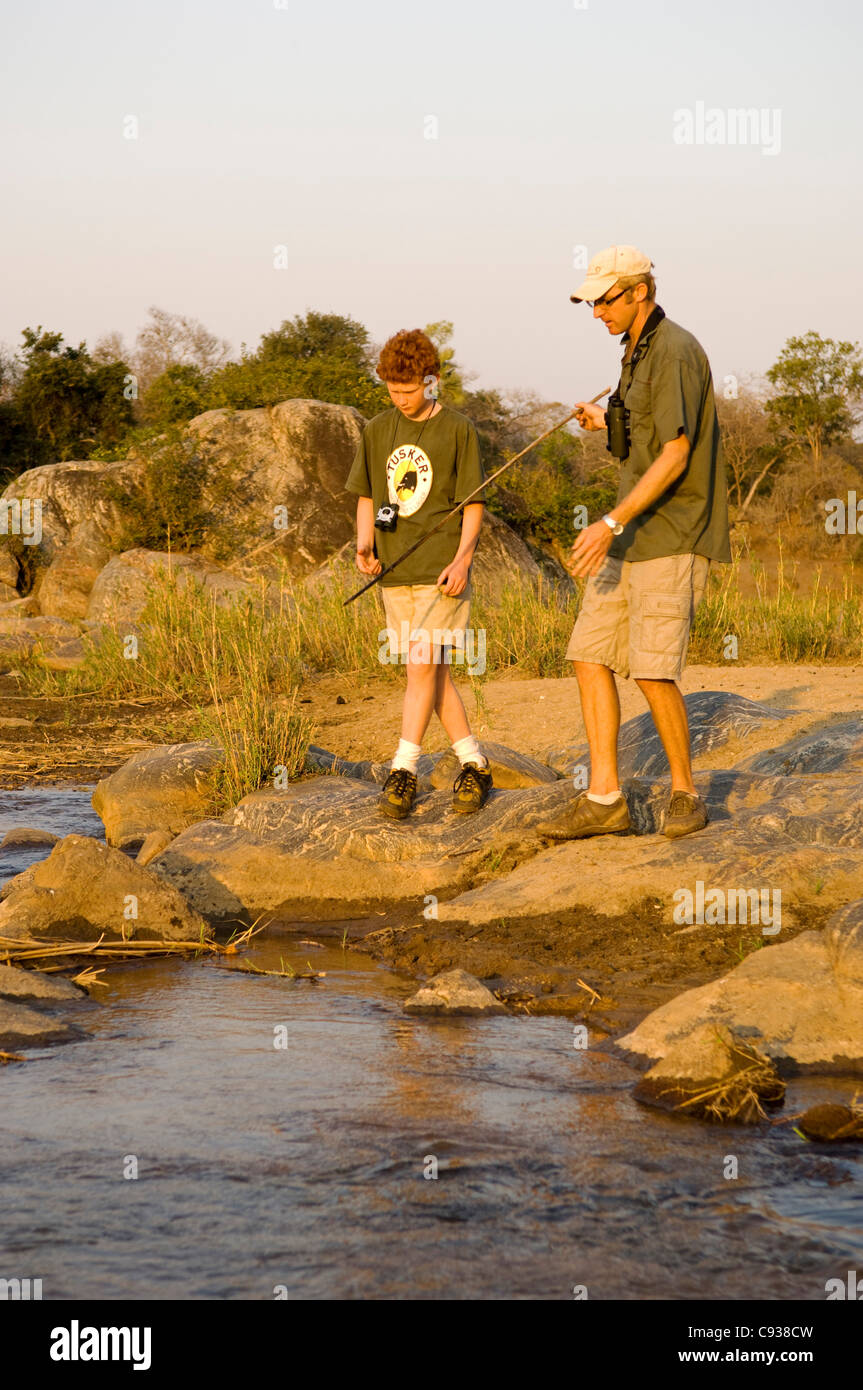 Il Malawi, Majete riserva faunistica. Guida Safari mostra come utilizzare una lancia per la cattura di pesce su una famiglia safari. Foto Stock