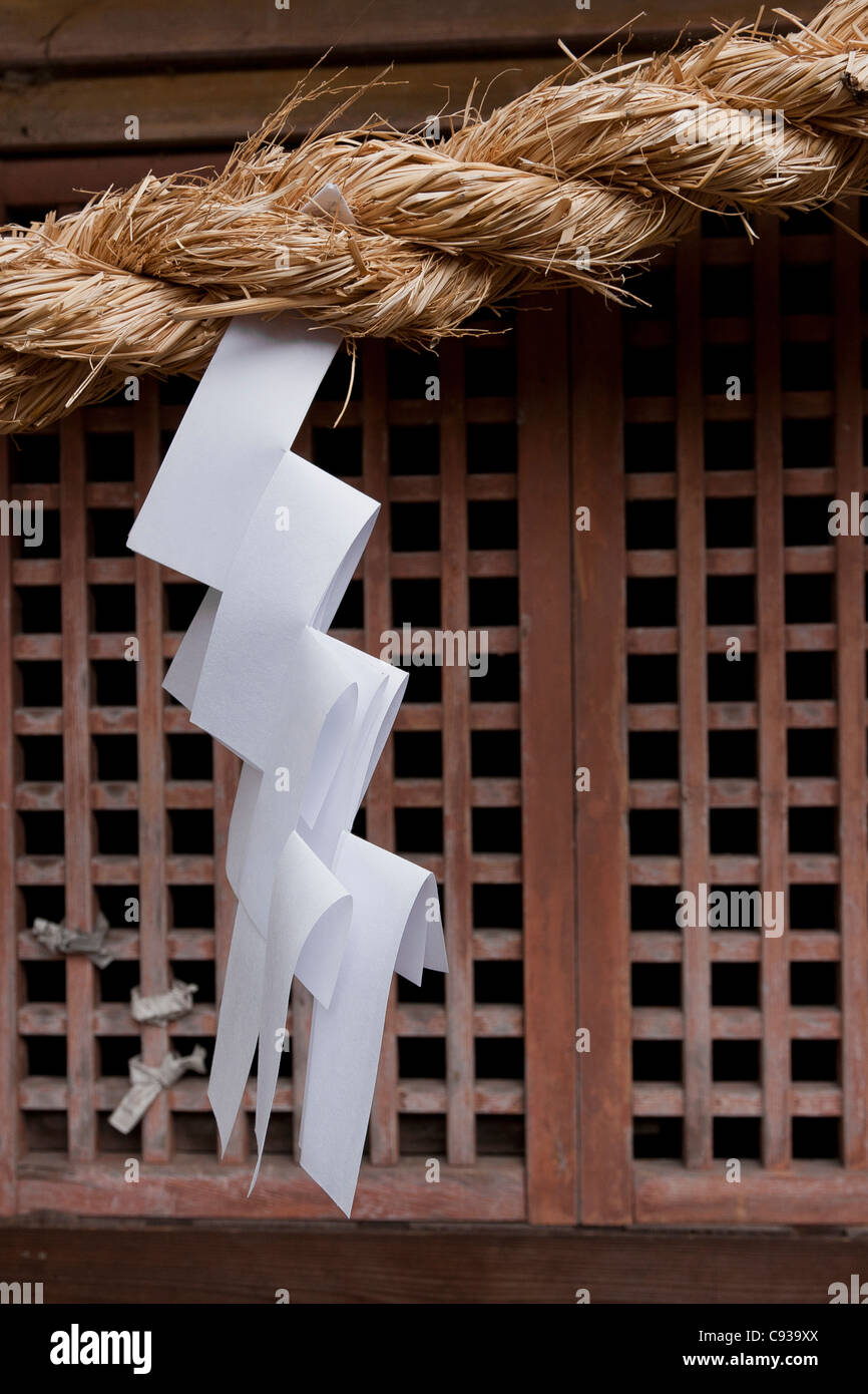 A zig zag, carta shide appesi ad una fune attraverso l'ingresso di un tempio Shintoista a Kanazawa, Ishikawa, Giappone Foto Stock