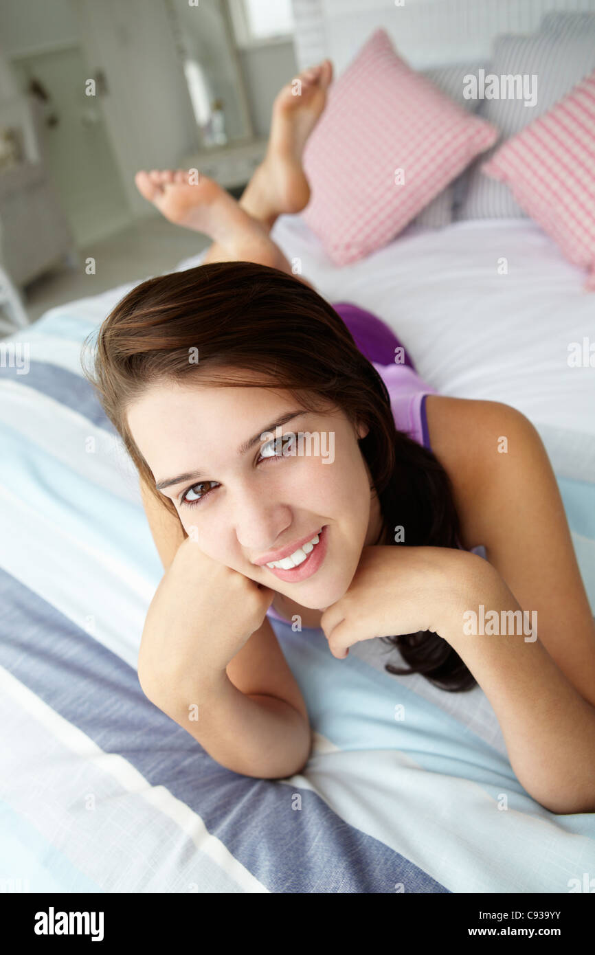 Ragazza adolescente rilassante sul letto Foto Stock