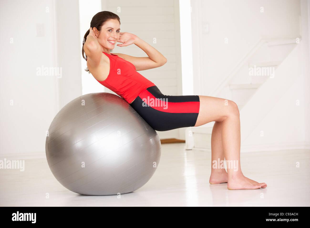 Donna con palla in home palestra Foto Stock