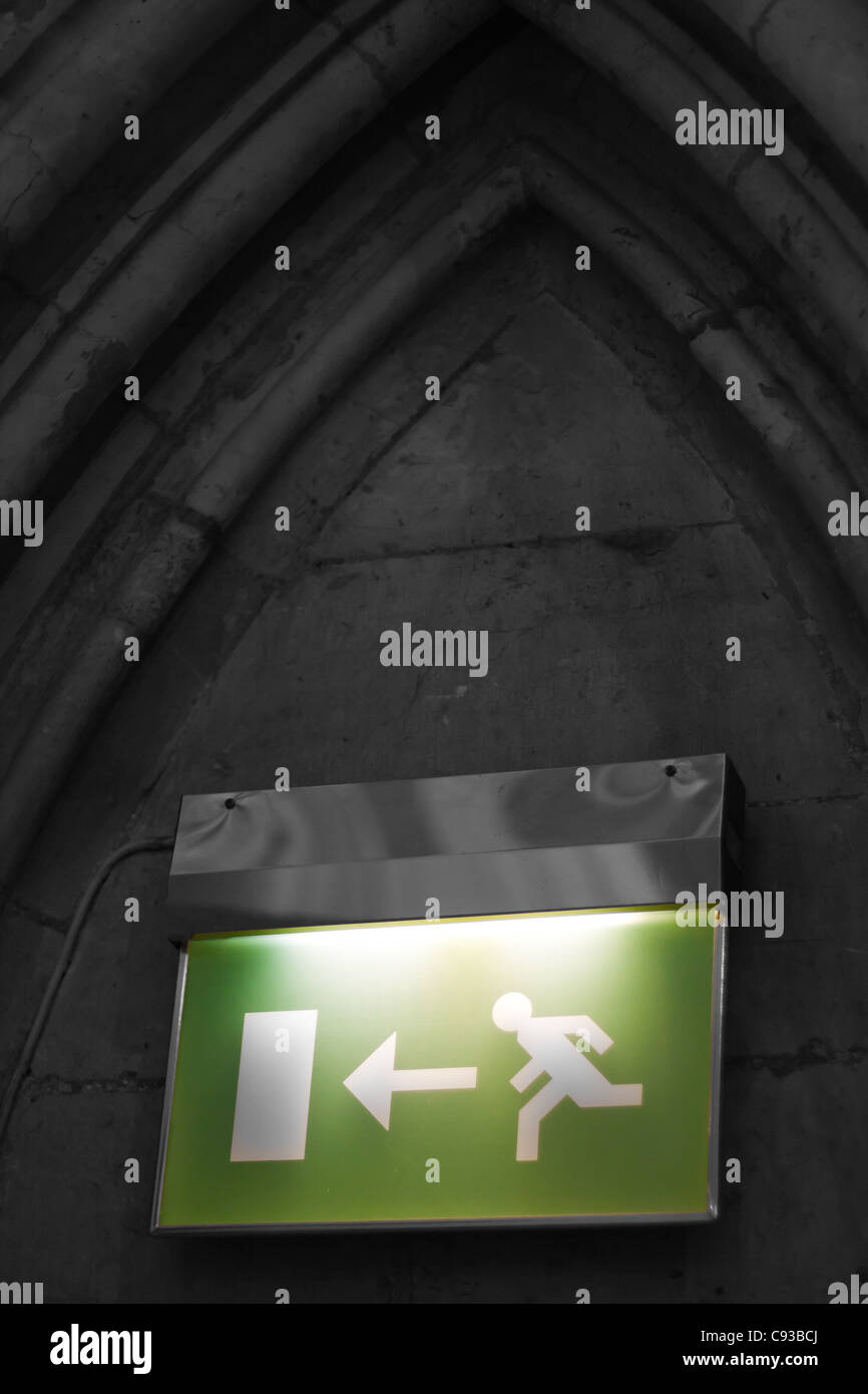 Una uscita antincendio cartello informativo in verde illuminato, in una chiesa cattedrale Foto Stock