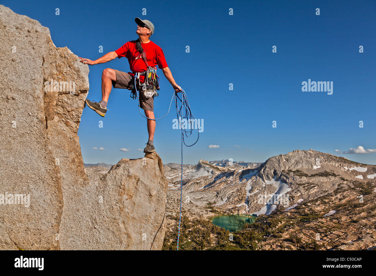 Maschio di rocciatore festeggia sul vertice dopo una salita di successo. Foto Stock