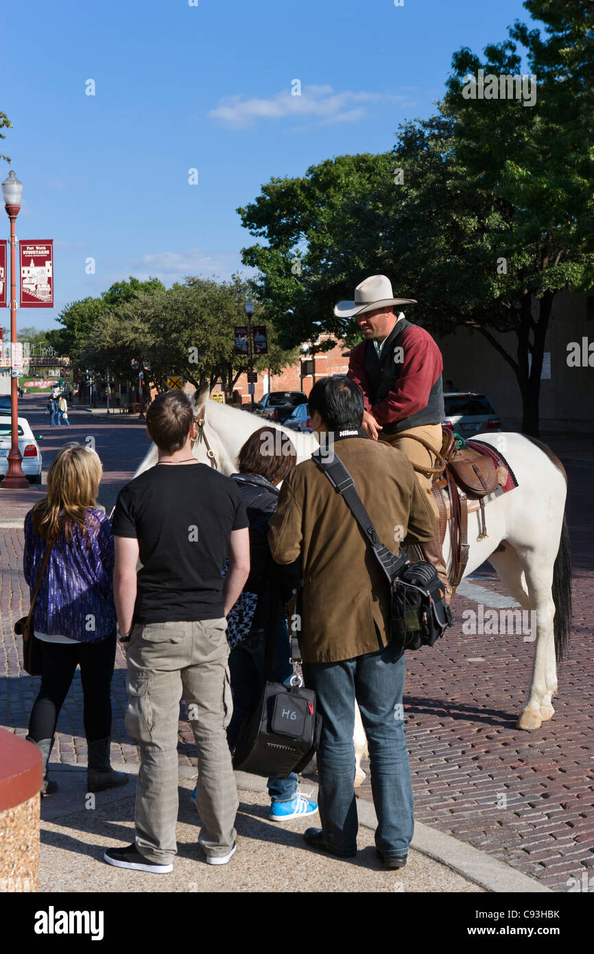 I turisti a parlare con un cowboy a cavallo fuori Cowtown Coliseum, Exchange Avenue, Stockyards distretto, Fort Worth, Texas, Stati Uniti d'America Foto Stock