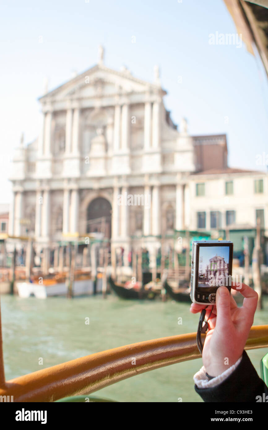 Una ragazza prende le fotografie con un punto-e-shoot fotocamera dal traghetto a Venezia, Italia. Foto Stock