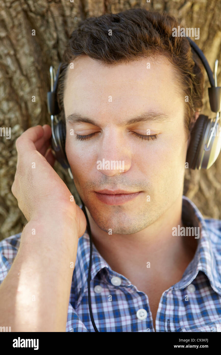 Giovane uomo ascoltare musica all'aperto Foto Stock