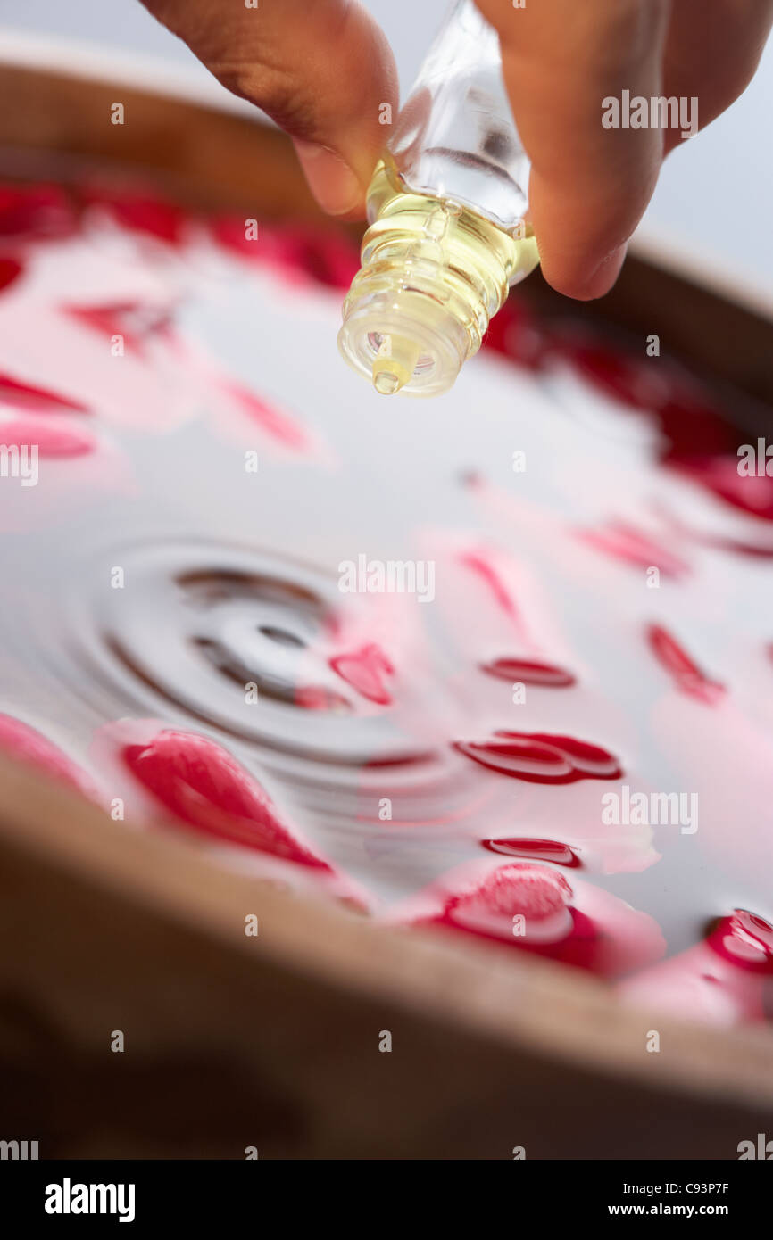 L'uomo versando olio essenziale in acqua Foto Stock