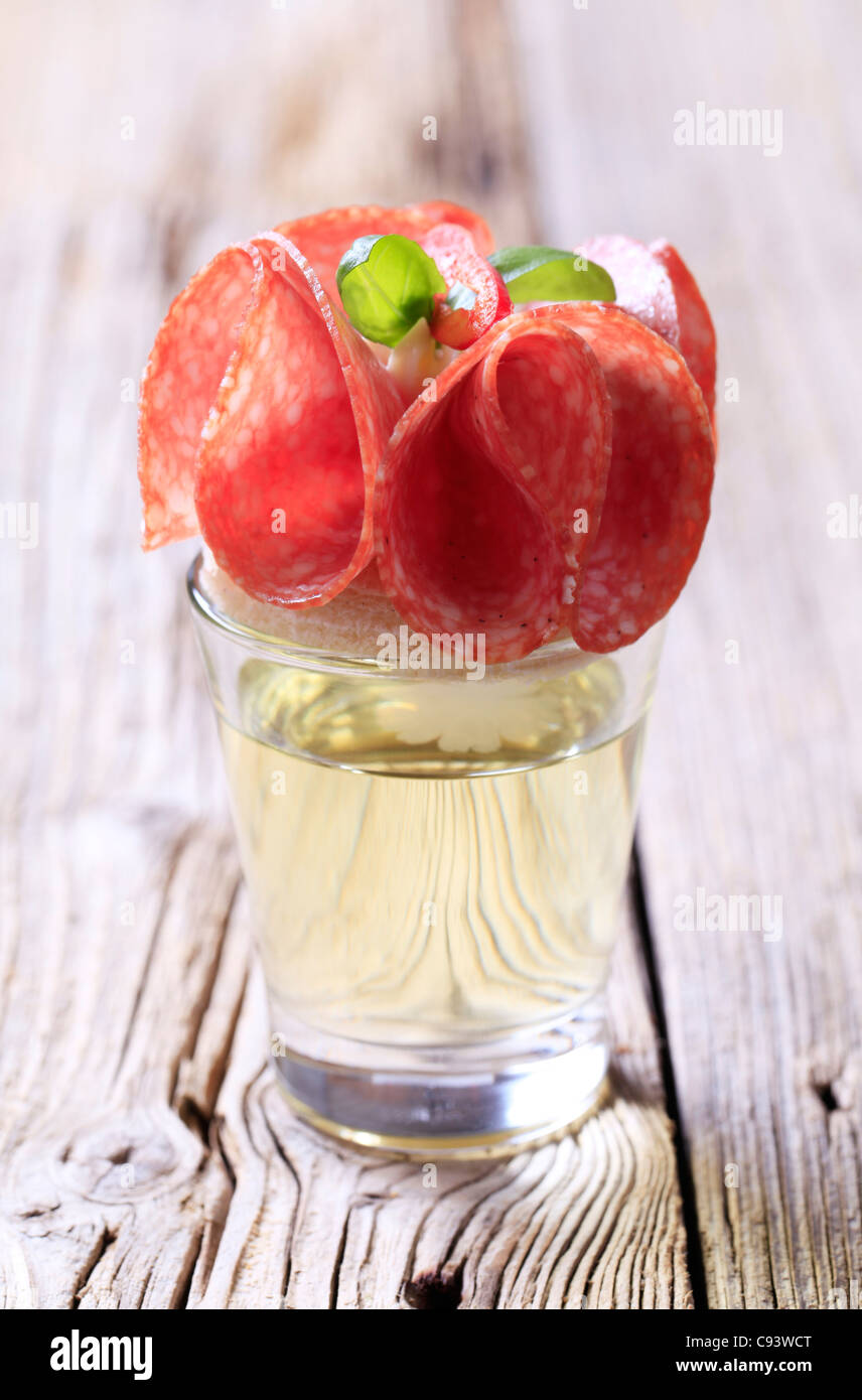 Salame crostino su un bicchiere di liquore Foto Stock