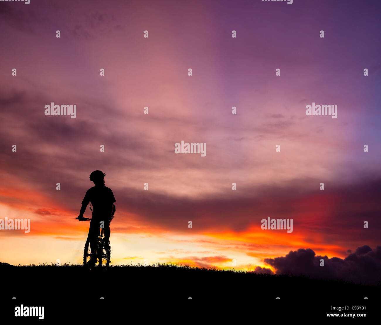 La silhouette di mountain bicycle rider sulla collina con un bellissimo sfondo di sunrise Foto Stock