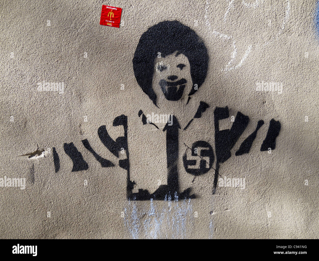 Anti-McDonald's graffiti mostra Ronald McDonald con una croce uncinata Foto Stock