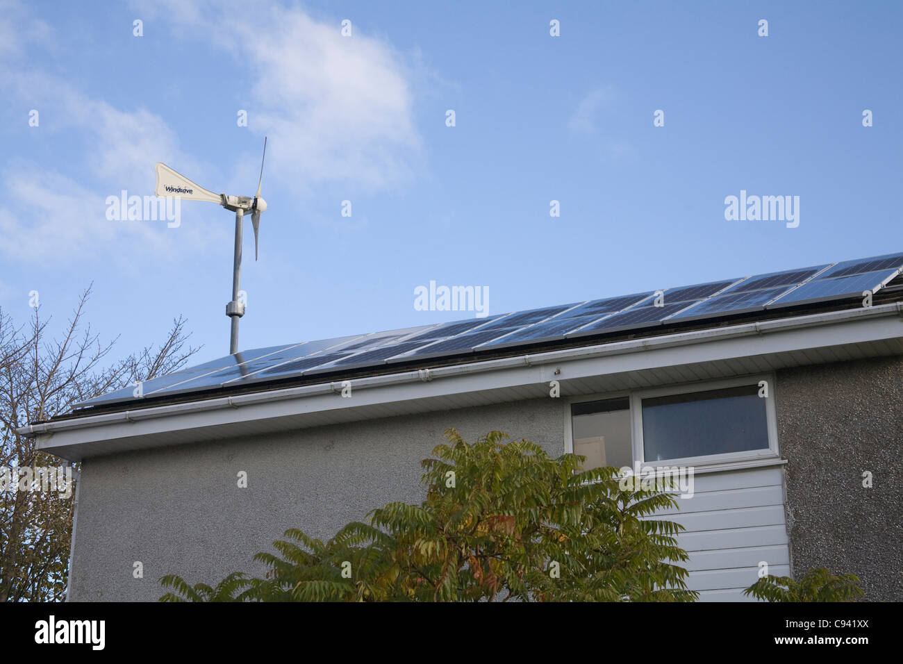Regno Unito turbina eolica e pannelli solari montati sotto il feed in regime tariffario in un ambiente domestico del tetto per generare elettricità Foto Stock