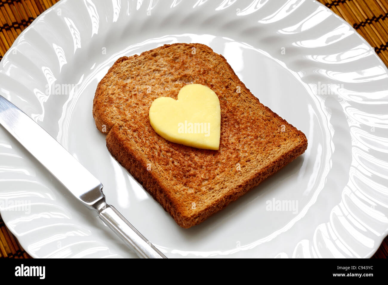 A forma di cuore di burro sul pane tostato Foto Stock