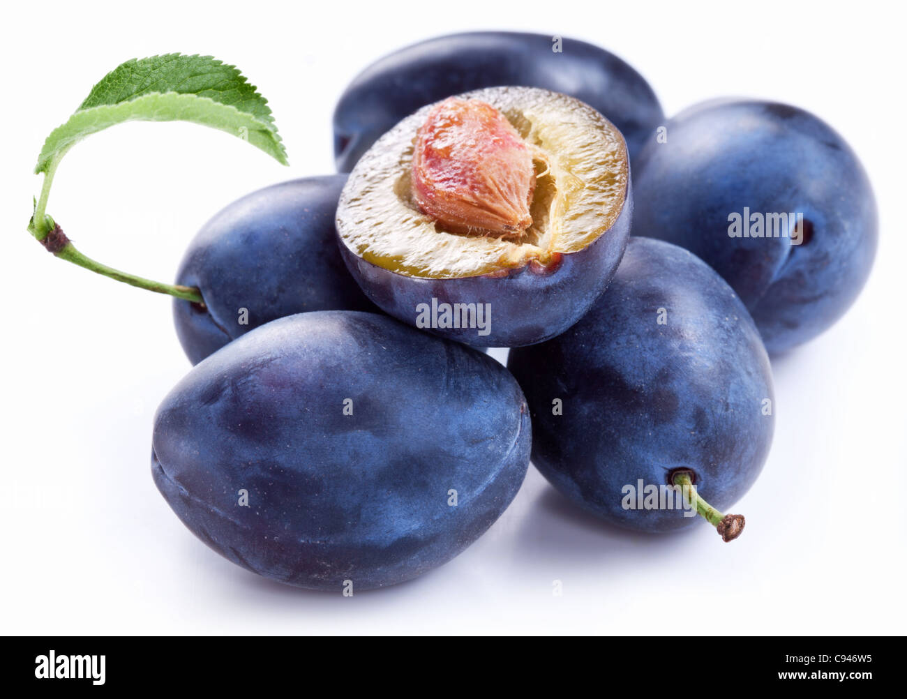 Gruppo di prugne con foglie isolate su uno sfondo bianco. Foto Stock