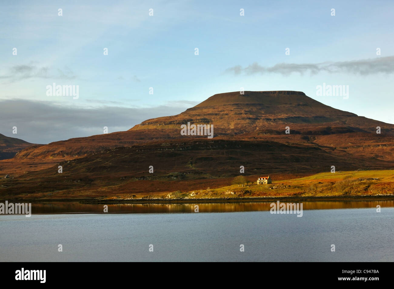 Un piccolo telecomando cottage si trova sulla riva di Isola di Skye nelle Ebridi Esterne della Scozia, al tramonto in primavera Foto Stock