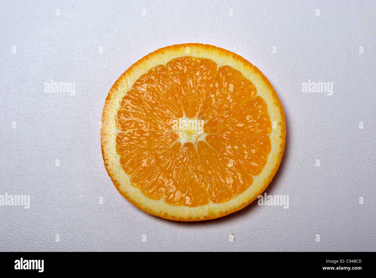 Una fetta di orange si siede su uno sfondo bianco. Foto Stock
