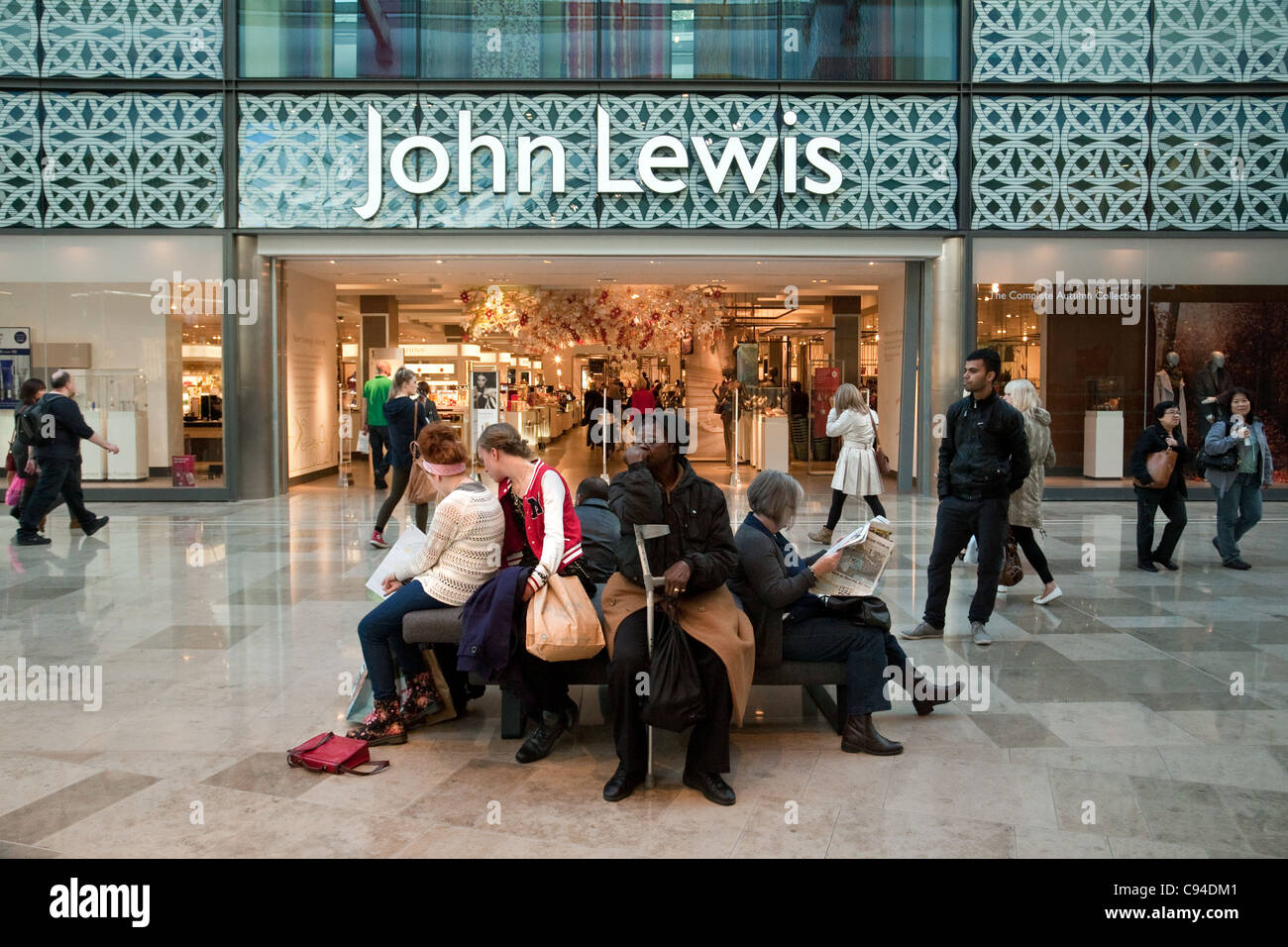 La gente seduta al di fuori del John Lewis Store, il centro commerciale Westfield Stratford London REGNO UNITO Foto Stock