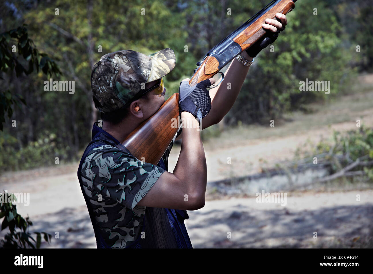 Clay piccione tiro uomo usando un fucile che prende lo scopo di un tiro al piccione di argilla Foto Stock