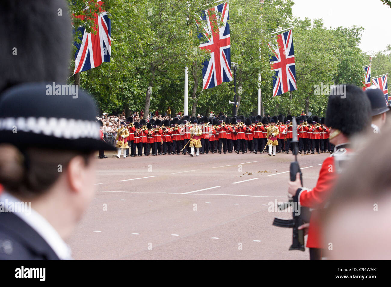 Le protezioni del piede bande con tamburo Major marciando verso Buckingham Palace, London, Regno Unito. Foto Stock