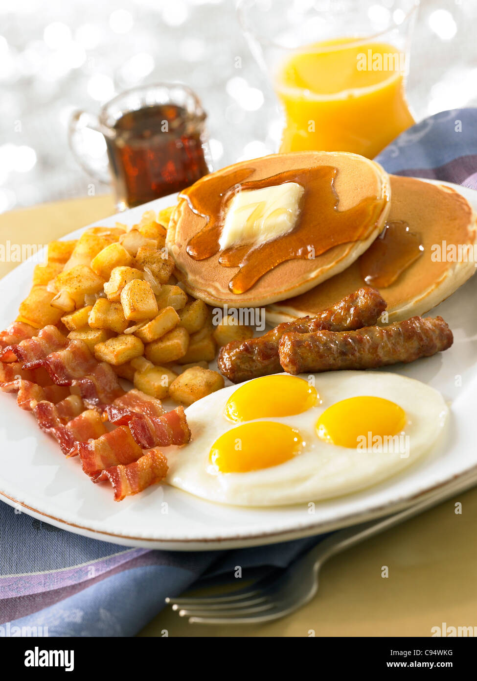 Frittelle con uova, pancetta, salsiccia, patate e succo di arancia Foto Stock