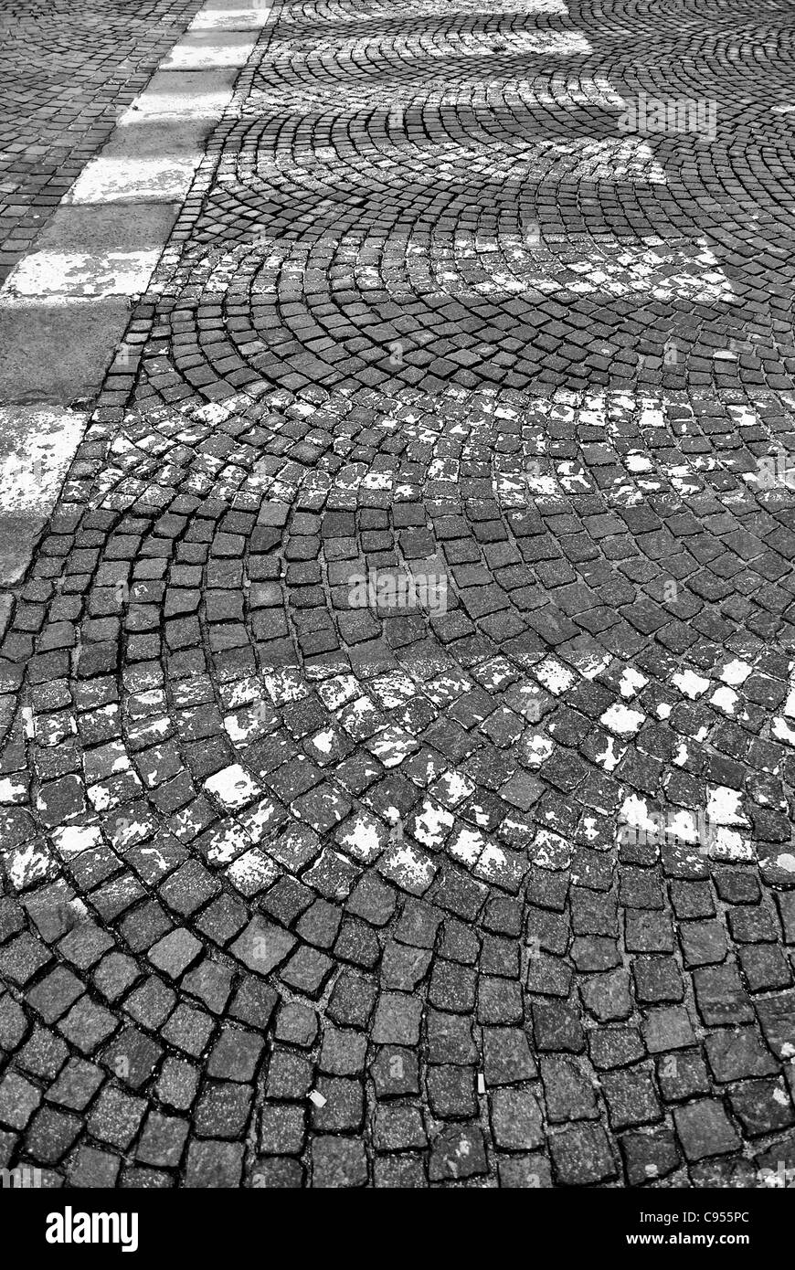 Le linee bianche della segnaletica stradale su blocchi di pietra road Foto Stock