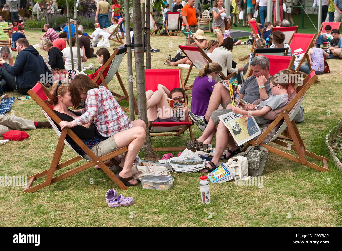 Una famiglia rilassante tra gli eventi in una bella giornata estiva all'Hay Festival of Letterature, Hay-on-Wye, Galles, Regno Unito Foto Stock