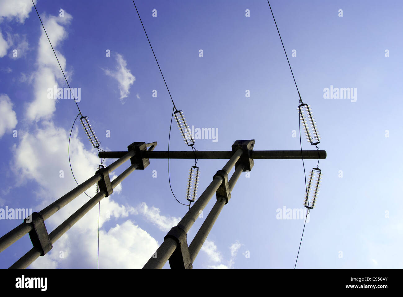 Elettricità pylyn contro blu cielo molto nuvoloso Foto Stock