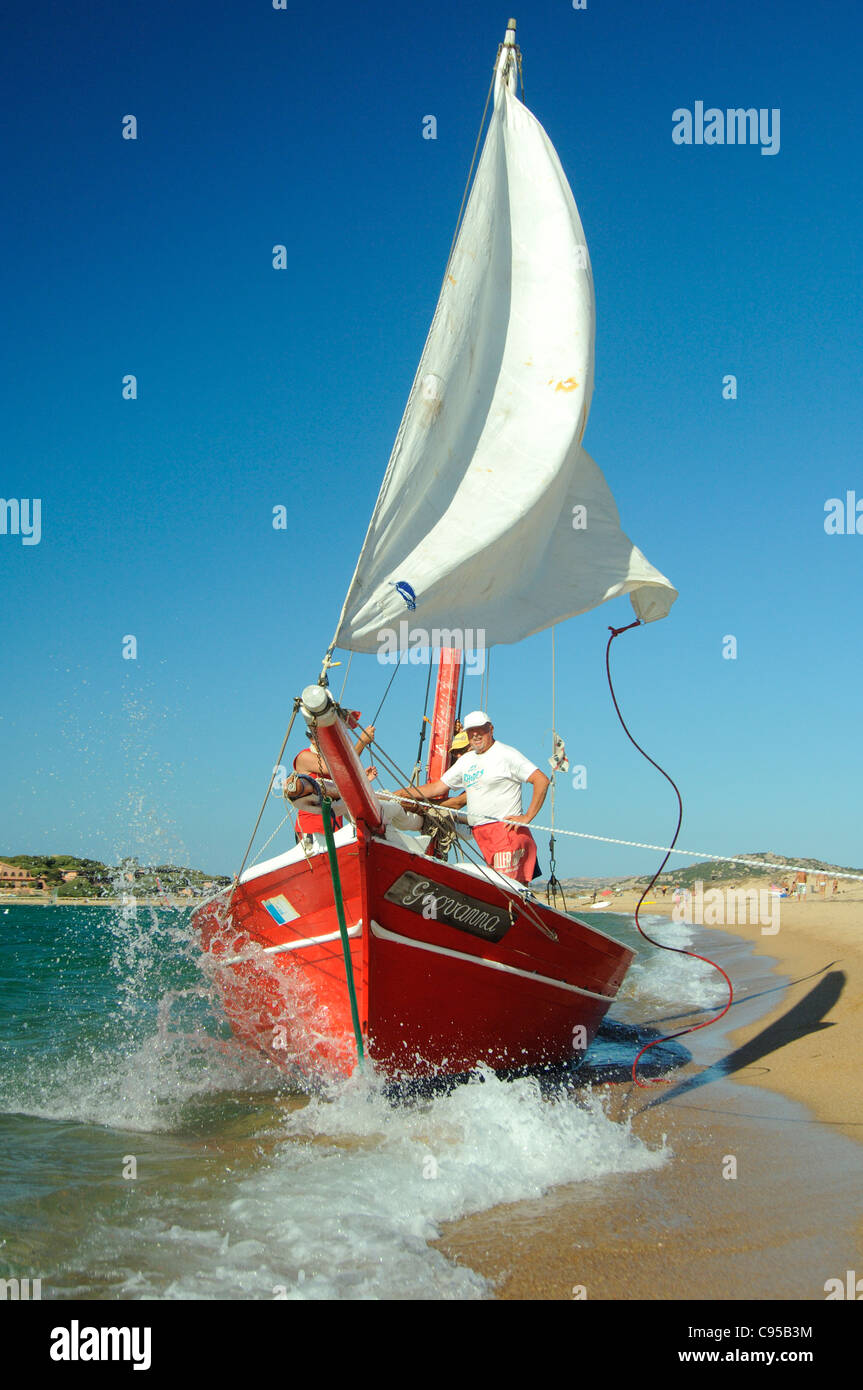 Vecchio latino classico barca vela in atterraggio a Porto Pollo beach, Palau Sardegna Foto Stock