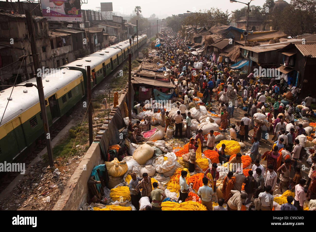 India Bengala Occidentale, Calcutta, Mullik Ghat, il mercato dei fiori, accanto la ferrovia suburbana linea con treno passa Foto Stock