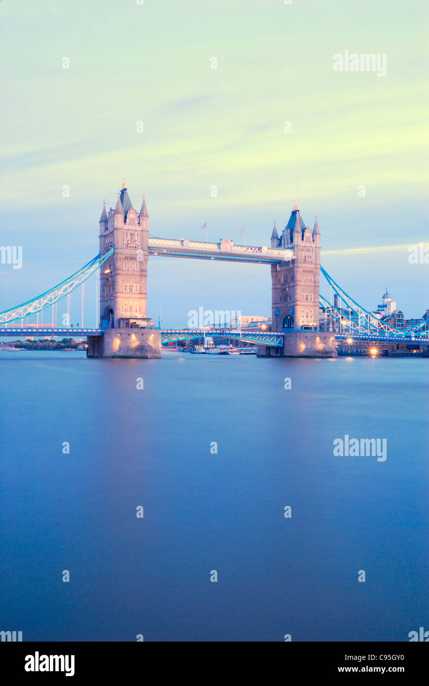 Colpo verticale di Tower Bridge al tramonto, con le due torri sono illuminati e Thames Water cercando blu. Foto Stock