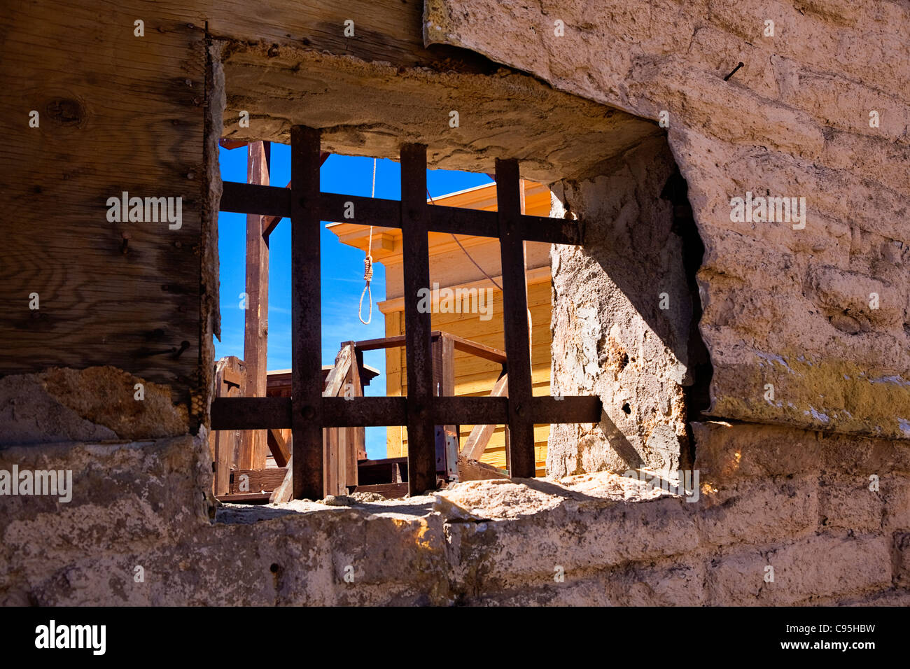 Immagine guardando attraverso il arrugginita le sbarre di una prigione oldtime finestra al patibolo e una hangmans cappio. Foto Stock
