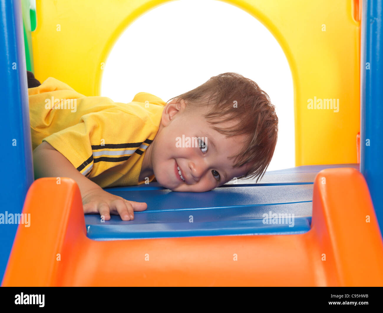 Felice circa un anno e mezzo il vecchio bambino arrampicata su una diapositiva. Isolato su sfondo bianco. Foto Stock