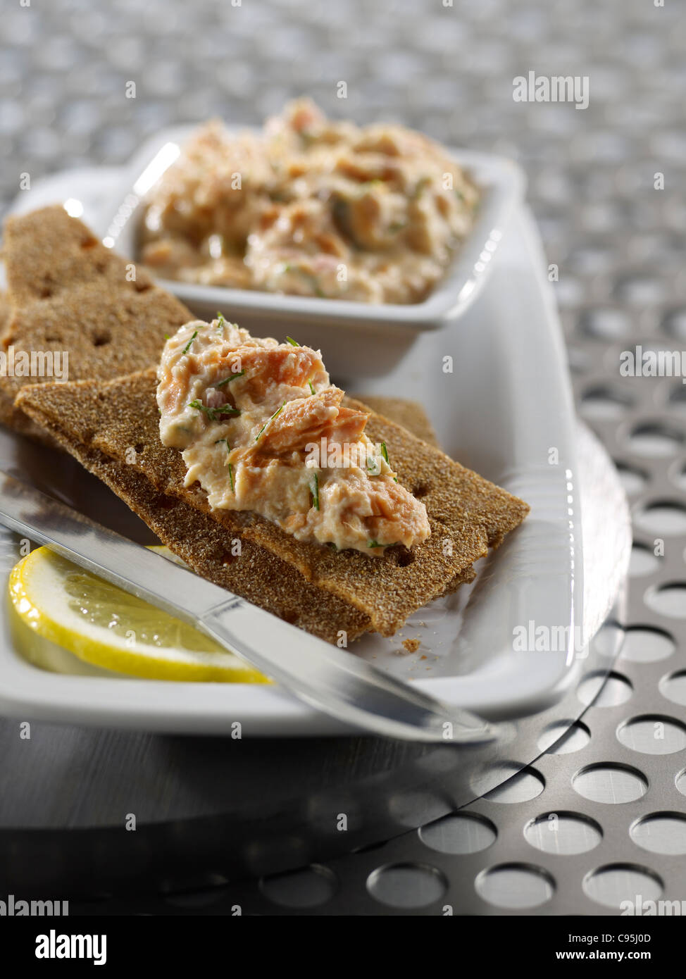 Salmone spalmato su cracker Foto Stock